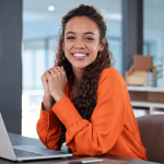 A young female sits at her desk, smiling at the opportunities provided through young talent programmes