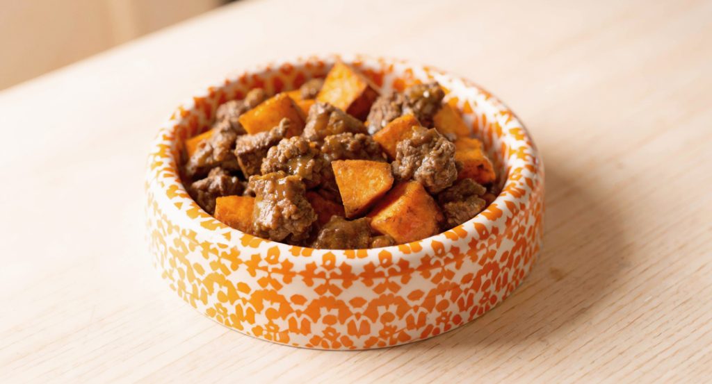 a comforting orange bowl of beef and sweet potato