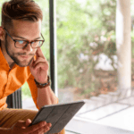 A man uses his tablet to research the difference between direct insurance vs a broker