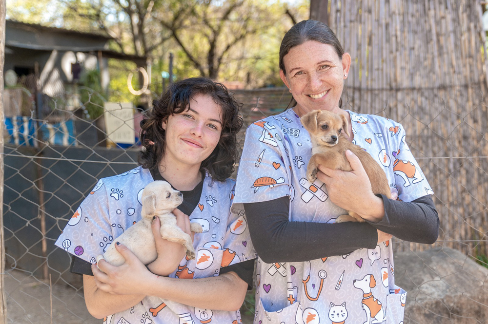 Two volunteers of WanderVet Animal Welfare Organisation holding puppies at the sterilisation drive in Sonheuwel on Mandela Day, 18 July 2026.