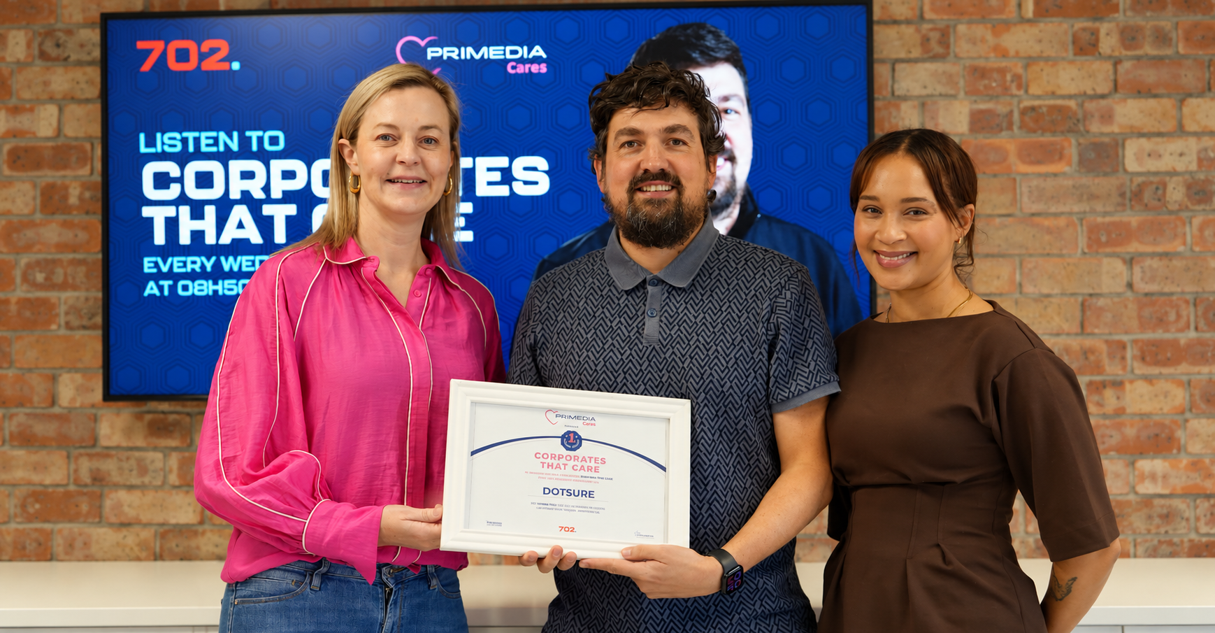 The Dotsure team with the Corporate that Cares certificate.