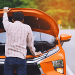A car parked safely on the side of the road as a man looks at his bonnet to understand if it is a mechanical failure vs wear & tear